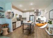 Thumbnail 14 of 22 - Apartments for Rent in Downtown Greenville - The Aster - Kitchen with White Cabinets, Freestanding Island, Barstools, and Appliances.