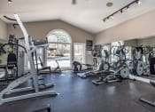 Thumbnail 33 of 44 - a gym with cardio machines and other exercise equipment and a window