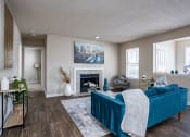 Thumbnail 26 of 44 - a living room with a blue couch and a fireplace