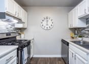 Thumbnail 22 of 44 - an open kitchen with stainless steel appliances and a large clock on the wall