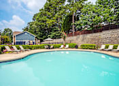 Thumbnail 12 of 18 - A swimming pool surrounded by trees and a building.