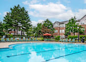 Thumbnail 1 of 29 - A swimming pool in front of apartment buildings.