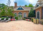 Thumbnail 9 of 18 - A brick house with a green door and a brick patio.