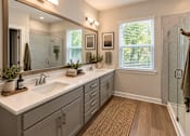 Thumbnail 43 of 56 - A bathroom with two sinks and a large mirror.