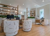 Thumbnail 5 of 56 - A modern office space with white furniture and wooden shelves.