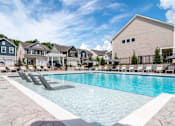 Thumbnail 1 of 56 - A swimming pool with lounge chairs in front of a row of houses.