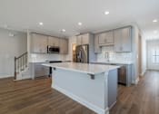 Thumbnail 46 of 56 - A modern kitchen with a large island and stainless steel appliances.