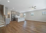 Thumbnail 50 of 56 - A spacious kitchen with wooden floors and a ceiling fan.