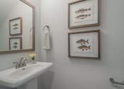 Thumbnail 29 of 56 - A bathroom with a white sink and three fish pictures on the wall.