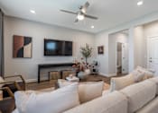 Thumbnail 20 of 56 - A living room with a white couch and a ceiling fan.