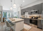 Thumbnail 17 of 41 - A modern kitchen with a dining table and chairs.