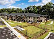 Thumbnail 39 of 50 - an aerial view of an apartment complex with a tennis court and lawn
