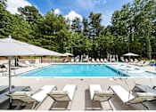 Thumbnail 31 of 50 - a swimming pool with lounge chairs and umbrellas