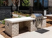 Thumbnail 37 of 50 - a brick outdoor grill area in front of a fence