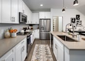 Thumbnail 11 of 50 - a large kitchen with white cabinets and stainless steel appliances