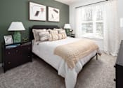 Thumbnail 22 of 50 - 1-Bedroom Apartments in Acworth, GA - The Brookstone - Bedroom with Plush Carpeting, Bed, Nightstands with Drawers and Lamps, Dresser, and Large Window.
