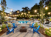 Thumbnail 2 of 50 - a patio with chairs and a pool at night