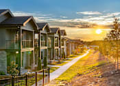 Thumbnail 41 of 50 - One-Bedroom Apartments in Acworth, GA - The Brookstone - Exterior View of Apartment Homes with Concrete Walking Path, Manicured Grass, and Trees.