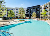 Thumbnail 23 of 26 - A swimming pool in front of apartment buildings.