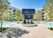 Thumbnail 20 of 26 - A large building with a pool in front of it.