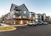 Thumbnail 1 of 28 - Huntsville, AL, Aparments Near Top Golf - The Collins - Exterior View Of The Leasing Office With Maintained Landscaping and Parked Vehicles
