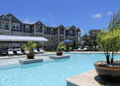 Thumbnail 23 of 29 - a large swimming pool with an apartment building in the background
