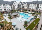 Thumbnail 1 of 56 - an aerial view of a resort style pool with lounge chairs and umbrellas