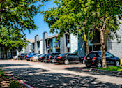 Thumbnail 19 of 22 - A row of cars parked in front of a building.
