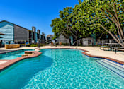 Thumbnail 12 of 22 - A swimming pool with a blue tiled edge and a red brick border.