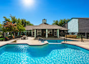 Thumbnail 1 of 22 - A pool in front of a house with a sunny sky.