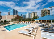 Thumbnail 31 of 44 - Buckhead, GA, Luxury Apartments with In-Unit Washers and Dryers- The Huntley - Heated Saltwater Pool with Sundeck, Lounge Chairs, and Umbrellas.