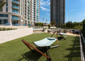 Thumbnail 34 of 44 - a rooftop lounge area with lounge chairs and a hammock