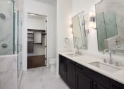 Thumbnail 27 of 44 - Two-Bedroom Luxury Apartments in Buckhead, GA - The Huntley - Bathroom with Dual Vanity Mirrors, Dual Sinks, Quartz Countertop, Shower, and Large Closet.