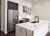 Thumbnail 26 of 44 - a kitchen with an island and stainless steel appliances