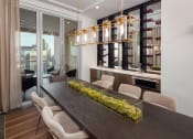 Thumbnail 11 of 44 - a dining room with a long wooden table and white chairs