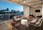 Thumbnail 40 of 44 - Luxury Apartments in Buckhead, GA, with In-Unit Washers and Dryers - The Huntley - Outdoor Terrace with Glass Railing, Area Rug, Couches, Chairs, Coffee Table, and Views of the City.