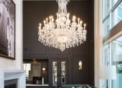 Thumbnail 5 of 44 - a large chandelier hangs above a large living room with green couches and a large