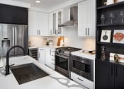 Thumbnail 17 of 44 - a kitchen with white countertops and black cabinets