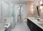 Thumbnail 22 of 44 - a bathroom with a large tub and a shower with a glass door