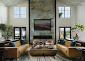 Thumbnail 7 of 31 - a living room with couches and a table and a fireplace