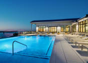 Thumbnail 30 of 47 - Apartments for Rent in Dowtown Memphis, TN - The Landing Residences - Rooftop Pool at Night with Lounge Chairs and View of River and Bridge