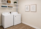 Thumbnail 11 of 15 - Two white front loading washing machines in a laundry room.