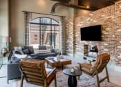 Thumbnail 11 of 28 - a living room with a brick wall and a large window