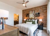 Thumbnail 21 of 28 - a bedroom with a bed and a brick wall