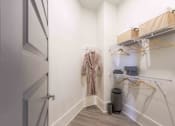 Thumbnail 26 of 28 - a walk in closet with a jacket hanging on the wall