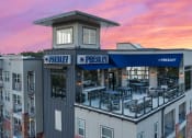 Thumbnail 20 of 45 - the facade of a building with tables and chairs at sunset