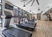 Thumbnail 12 of 45 - a gym with treadmills and other exercise equipment