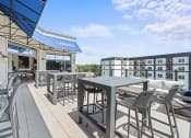 Thumbnail 19 of 45 - a patio with tables and chairs and a building in the background