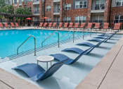 Thumbnail 34 of 45 - a swimming pool with chairs and a table in the middle