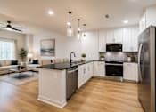 Thumbnail 2 of 50 - A modern kitchen with a black countertop and stainless steel appliances.